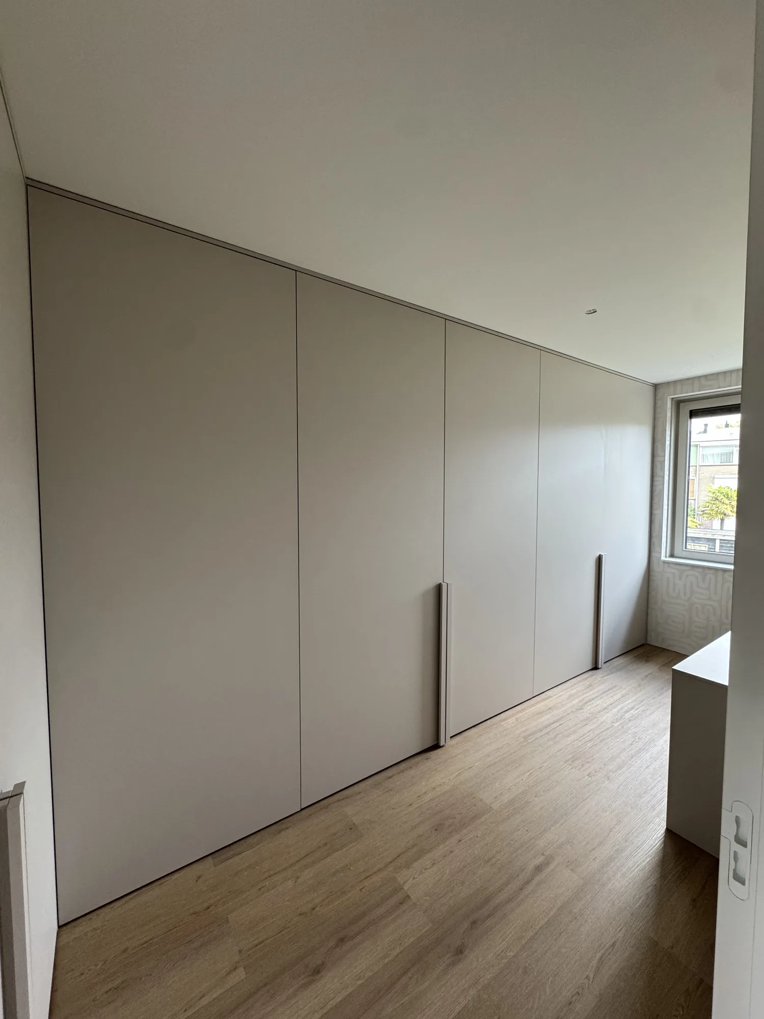 Greeploze kastenwand in greige van vloer tot plafond