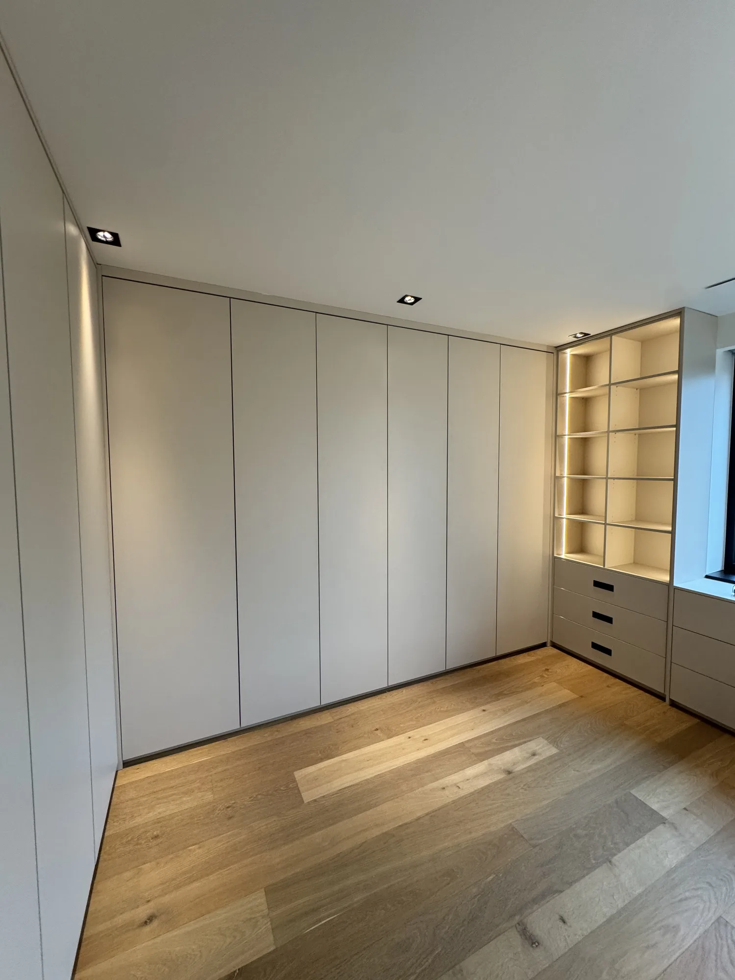 De gesloten kastenwand van de kleedkamer, met spots in het plafond