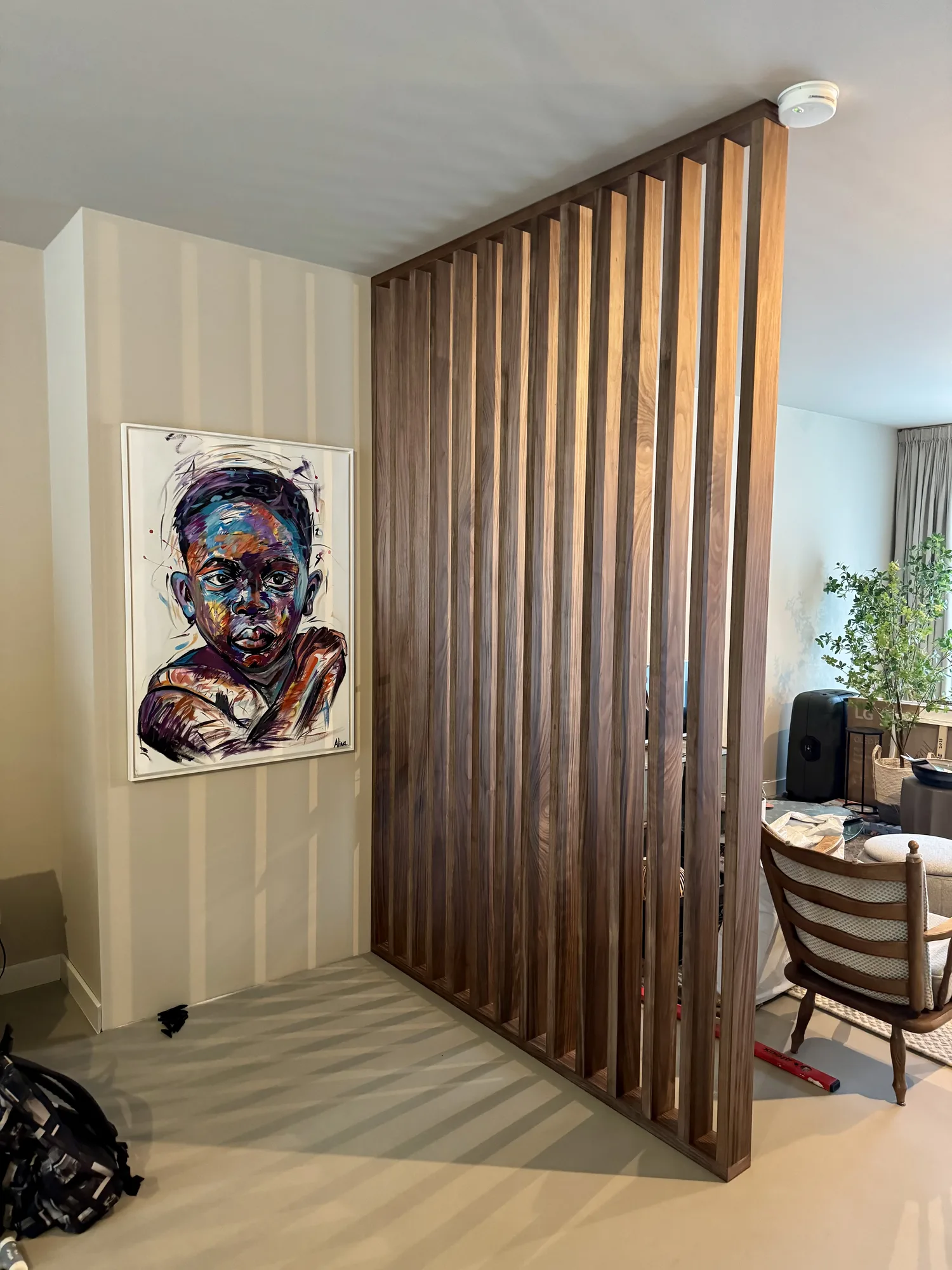 Lamellenwand in noten als scheiding tussen de hal en de woonkamer
