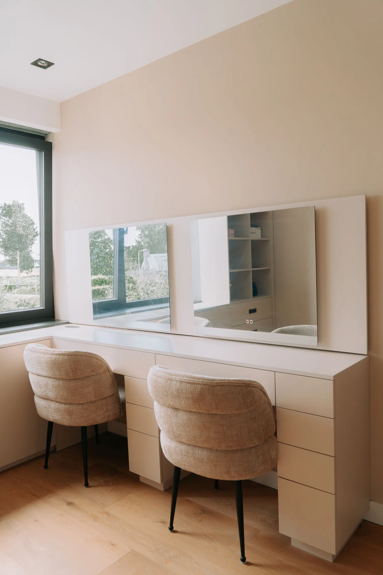 Kaptafel met spiegel en twee stoelen, ingebouwd tussen de kasten